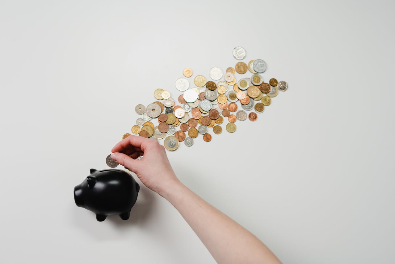 coins lining up to a black piggy bank
