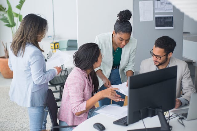 a  group of employees working at a desk together