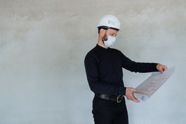 an inspector in a mask and hard hat