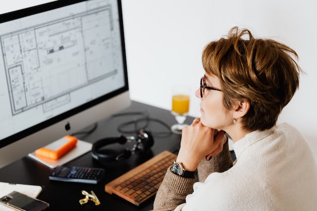person looking over an apartments blueprints on a computer